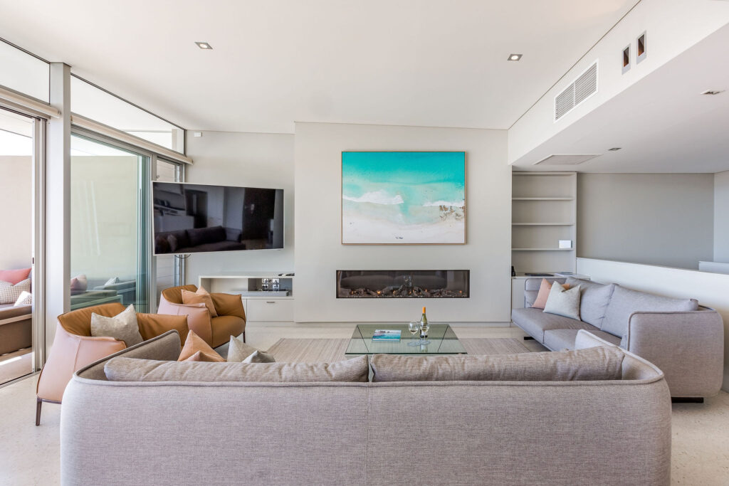 Lounge Room with fireplace and large beach artwork.